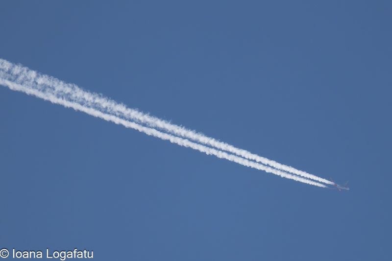 High-altitude jet trail against a clear blue sky